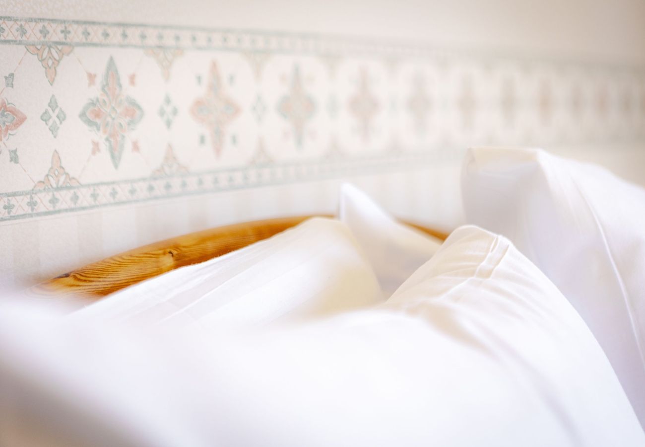 Detailed close-up of soft white cushions on a bed, creating a clean, serene, and elegant bedroom atmosphere.
