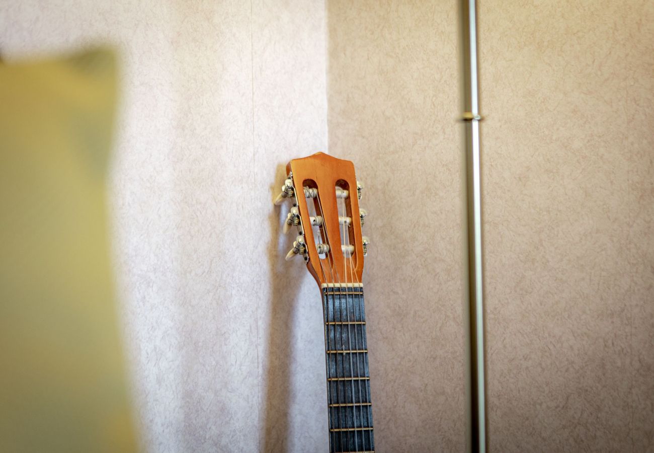 Simple and serene room corner featuring a single acoustic guitar