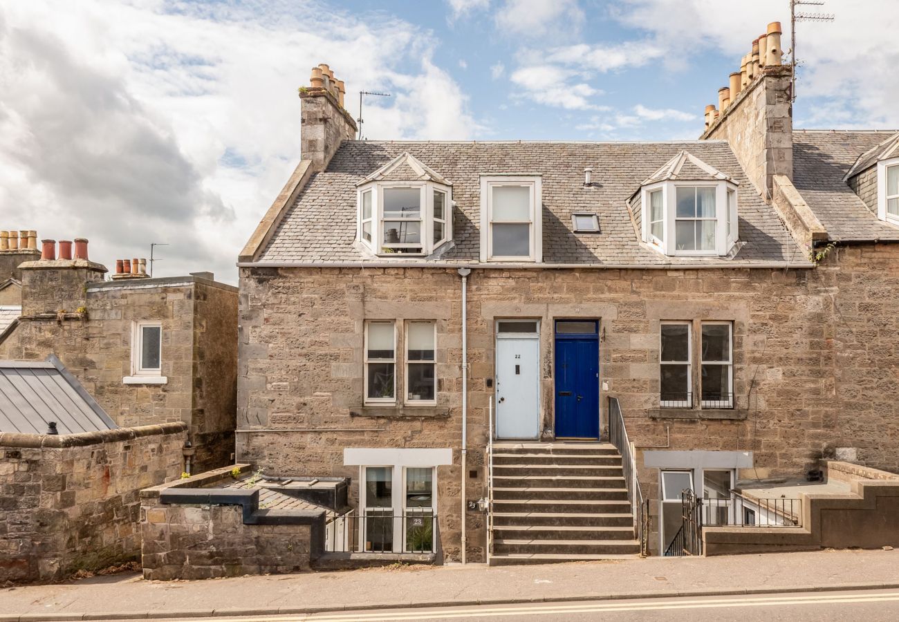 Street view of stone terraced building with blue and white doors.