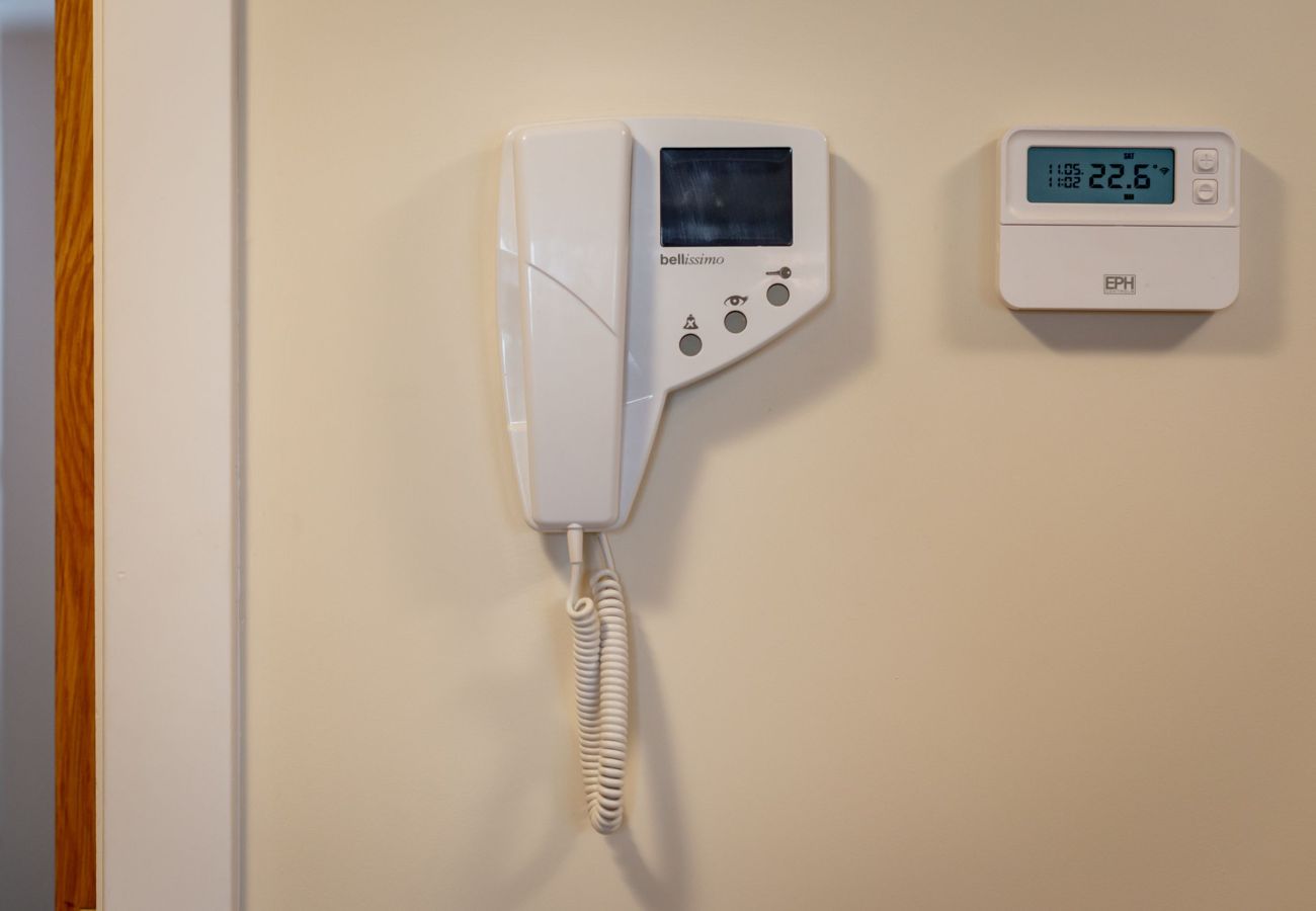 Wall-mounted intercom system and digital thermostat offering comfort and security in St Andrews apartment