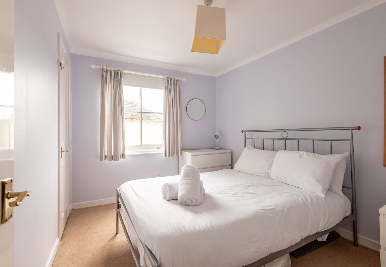 Calm double bedroom with metal bedstead and towels at Earls Lodge, Earlsferry—near St Andrews.