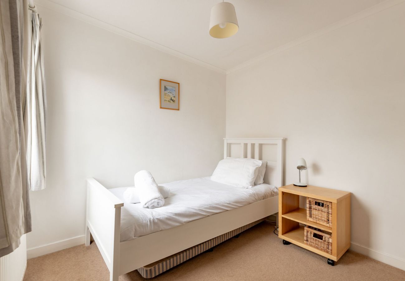Single room with window, bedside lamp and clean white bedding at Earls Lodge near Elie links golf.
