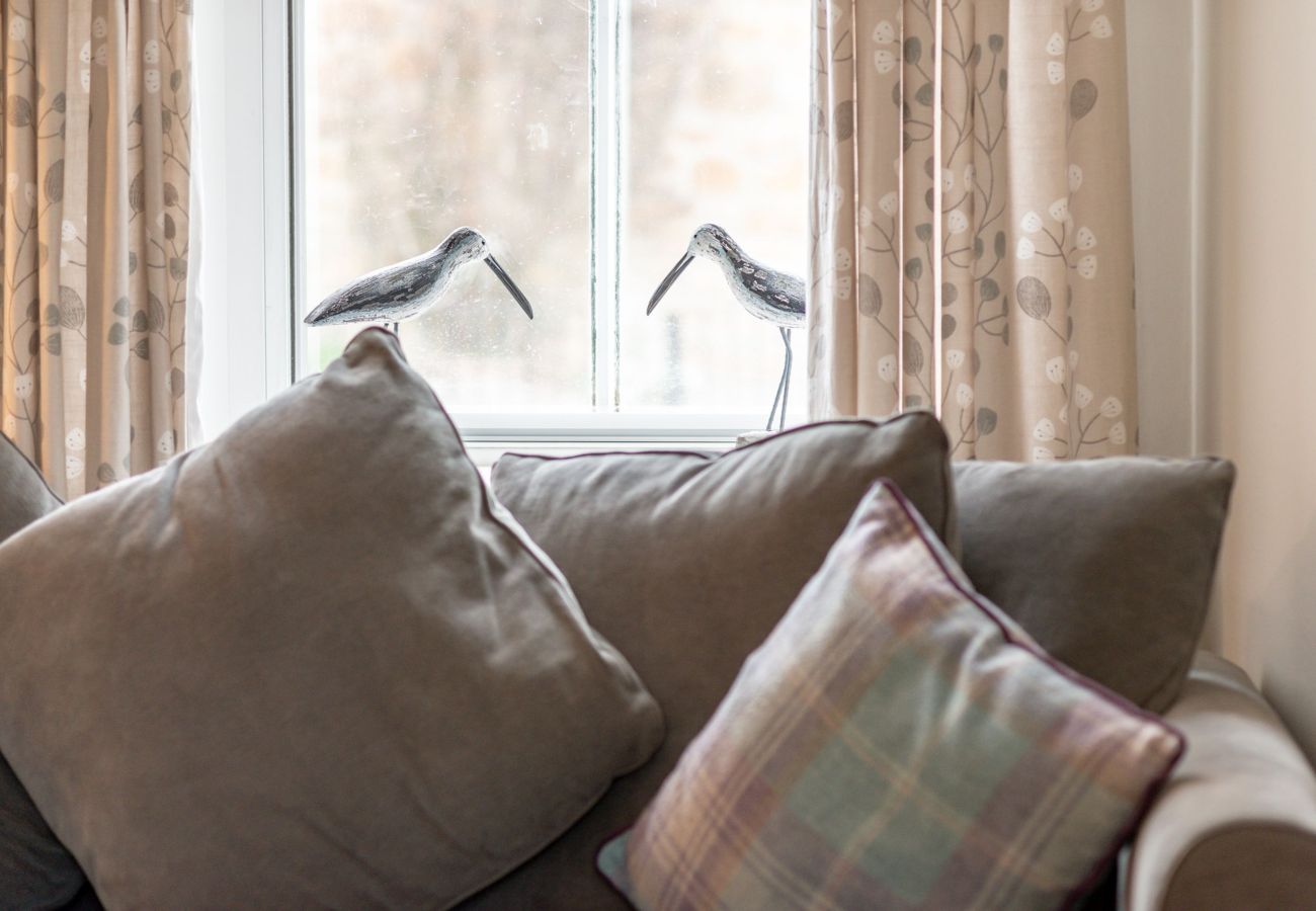 Sofa by window with bird ornaments at Earls Lodge, Earlsferry, East Neuk, near St Andrews.