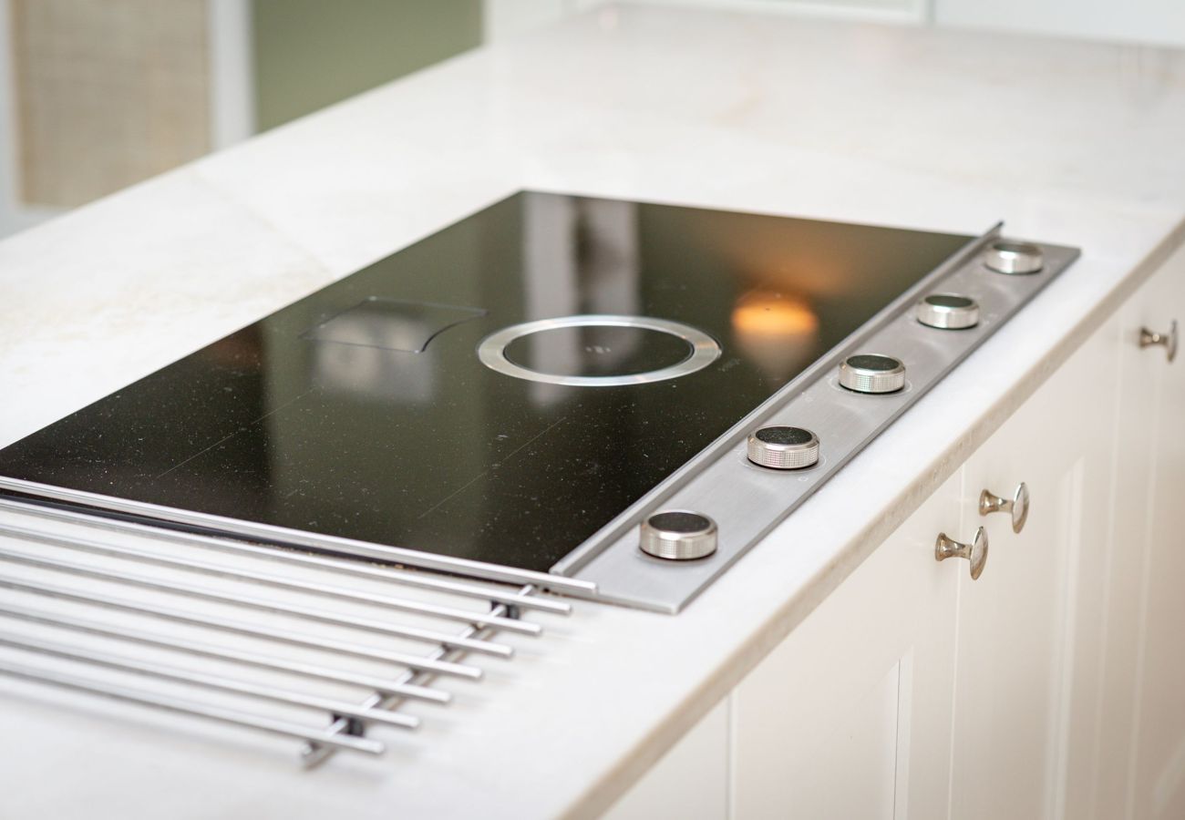 Sleek induction cooktop with integrated extractor on quartz island at 42 Lade Braes, St Andrews.