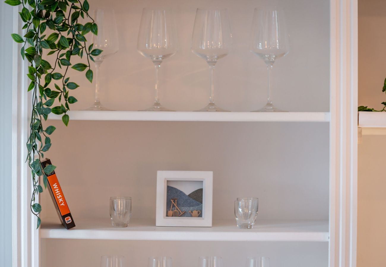 Open shelves with wine glasses, greenery and decor creating a homely touch at 42 Lade Braes holiday let, St Andrews.