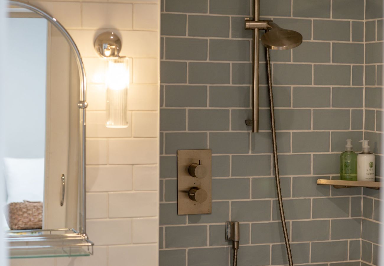 Walk-in shower with brushed chrome fittings and grey subway tiles at 42 Lade Braes holiday home, St Andrews.